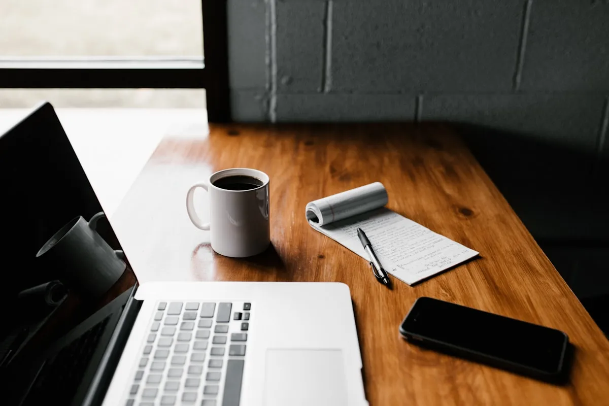 A person working on a laptop at a clean desk with a coffee cup, representing focused productive work.